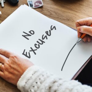 vrouw schrijft "no excuses" op stuk papier