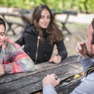 groep vrienden roken op een picknick bankje