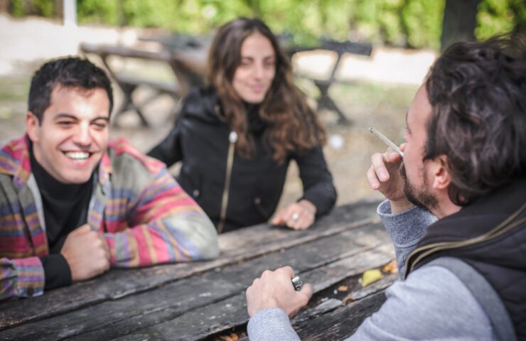 groep vrienden roken op een picknick bankje