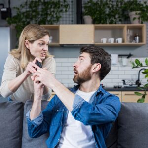 vrouw met kort lontje pakt telefoon van man af