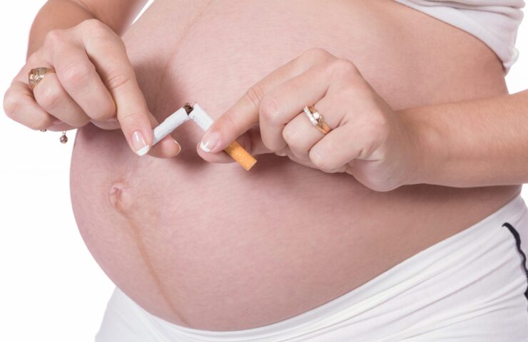 zwangere vrouw die sigaret breekt