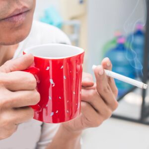 man met koffie en sigaret