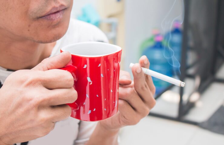 man met koffie en sigaret